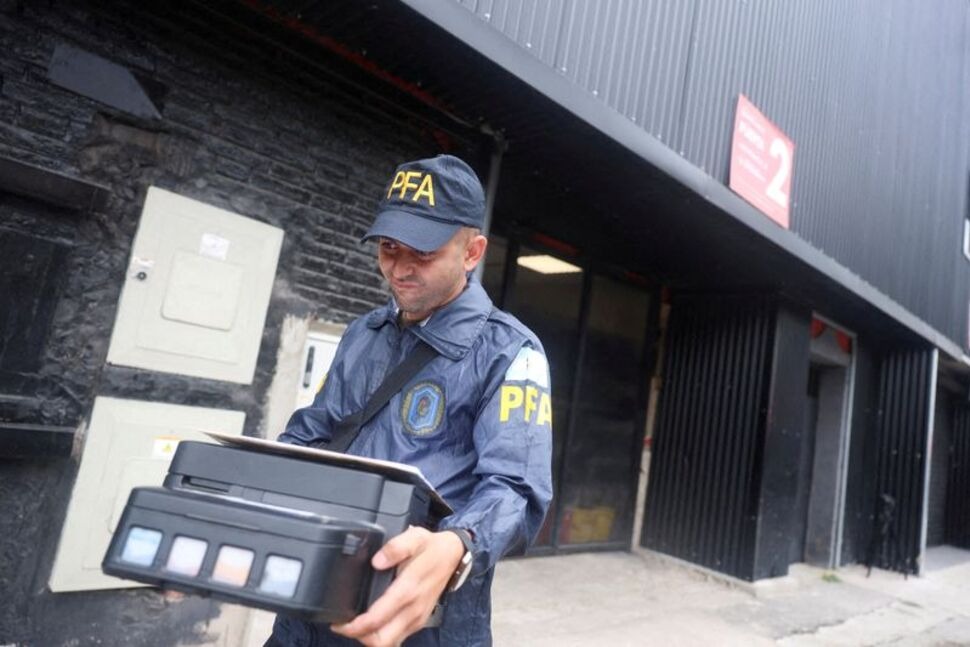 FILE PHOTO: A member of the Argentine Federal Police walks after seizing a printer from the Claudio Chiqui Tapia stadium, which belongs to the soccer team Barracas Central, during a raid, amid an investigation into alleged money laundering involving the Argentine Football Association and a group of soccer clubs, according to local media, in Buenos Aires, Argentina, December 9, 2025. REUTERS/Cristina Sille/File Photo
